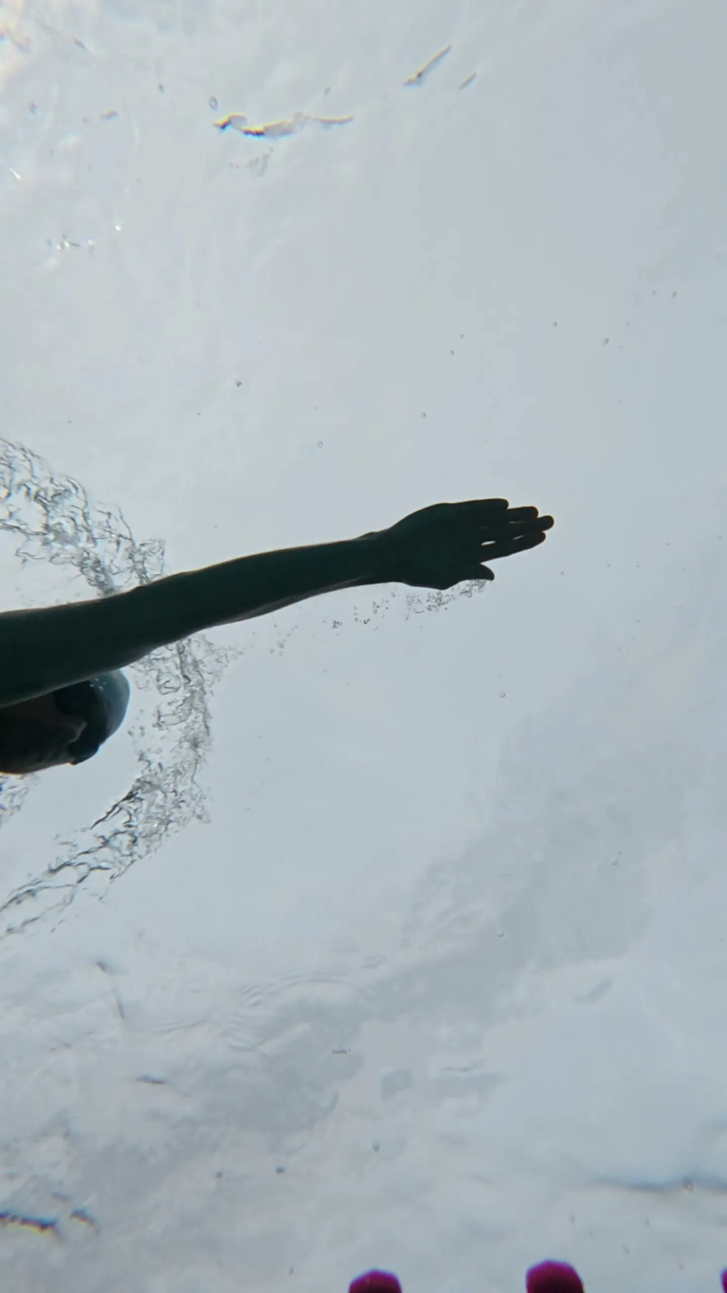 Onderwaterbeeld van de hand die naar voren reikt bij het begin van de armtrek